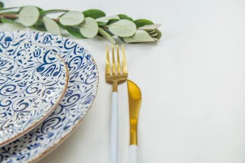 On the side, two serving plates with blue patterns on a white background stand Stock Photos