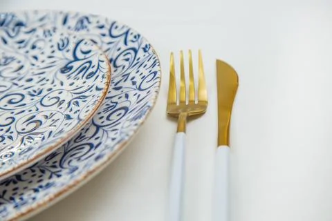 On the side, two serving plates with blue patterns on a white background stand Stock Photos