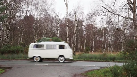 Side view of 1972 VW camper van driving on road past camera position Stock Footage 144556133