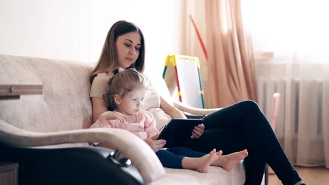 Side view, 4k: Young attractive mother and sweet daughter are sitting on the Vídeo Stock 105118498