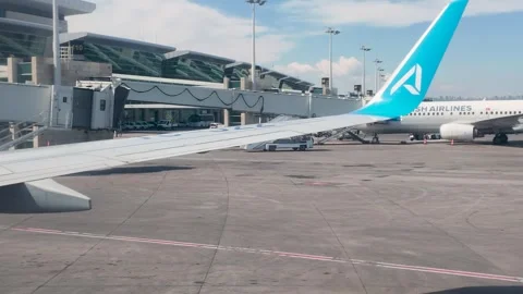 Side view of AJet passenger airplane winglet at boarding bridge. 스톡 동영상 336930644