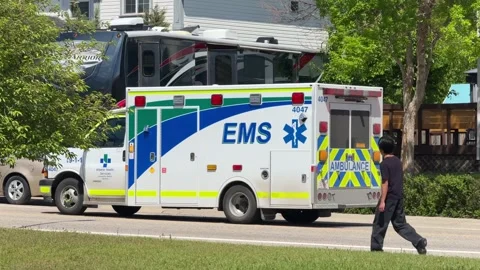 Side view of an Alberta Health Services EMS ambulance driving by Vídeo Stock 348746583