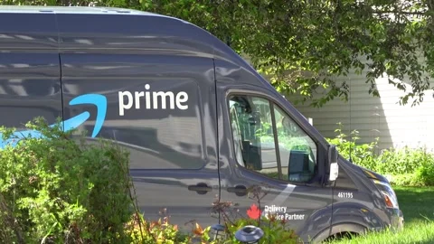 Side view of an Amazon Prime delivery van parked by a suburban house during day Stock Footage 337098768