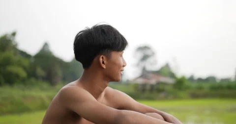 Side view and close up young farmer without shirt sitting on the ground  Stock Footage 202055199