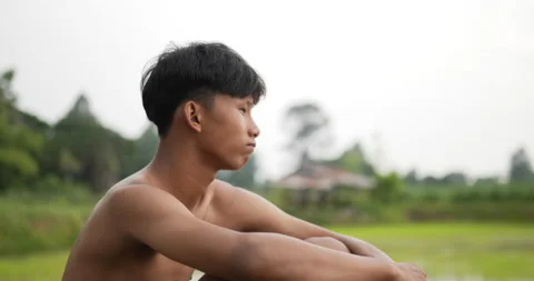 Side view and close up young farmer without shirt sitting on the ground  Stock Footage 202055269