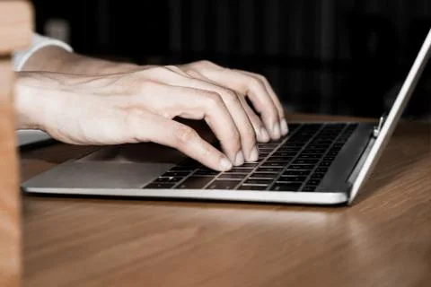 Side view and close up of young woman hands are typing on the modern laptop c Stock Photos