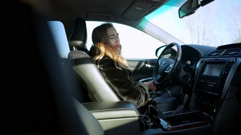Side view of angry depressed Caucasian young woman kicking steering wheel in Stock Footage 148753091