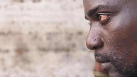 Side view of angry sad african young man leaning  staring at camera Stock Footage 218619376