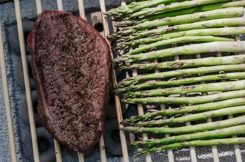 Side view Aparagus and steak on eco grill. Outdoor picnic in summer.Healthy Stock Photos