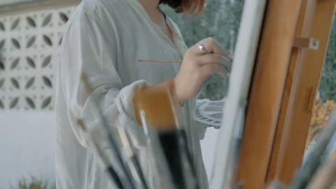 Side view of artist painter on patio 스톡 동영상 130617824