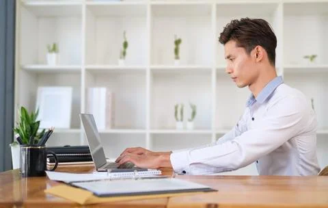 Side view of asian businessman checking news or business email on laptop co.. Stock Photos