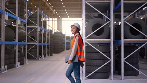 Side View of Asian Female Engineer Holding Tablet While Walking at Tire Stock Footage 341785122