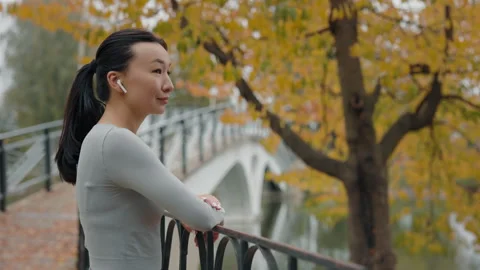 Side View of the Asian Female Runner Enjoying Outside Listening to Music. Jogger Stock Footage 266383074