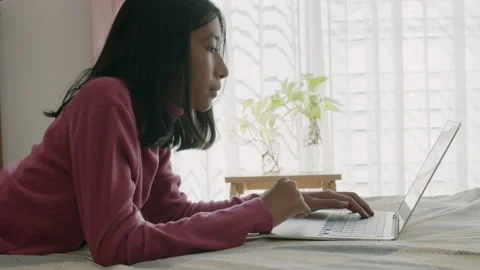 Side view of Asian girl using laptop, typing work on computer Video stock 146199327