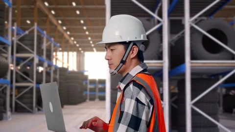 Side View of Asian Male Engineer Use Computer While Walking at Tire Warehouse Stock Footage 341783968