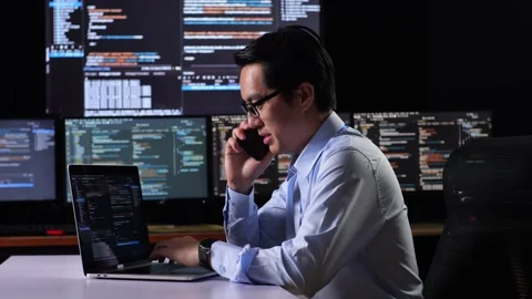 Side View Of Asian Male Programmer Looking At Smartphone Celebrating The Success Stock Footage 230183061