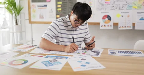 Side view of Asian man glasses checking to task on workplace desk while sitting Stock Footage 201920519