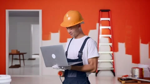 Side View Asian Man Painter Using A Laptop With Painting Wall In Room Stock Footage 283076550