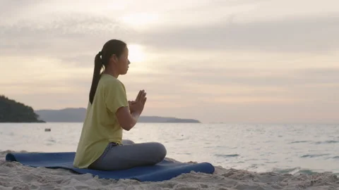 Side view of Asian woman Practicing yoga pray on beach sand Stock Footage 145299986