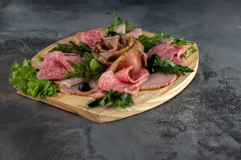 Side view assorted sliced delicious meat mix as salami, bacon and ham with pa Stock Photos