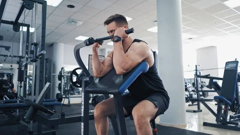 Side view of an athletic man during workout in a gym. Bodybuilder sitting Video stock 112381780