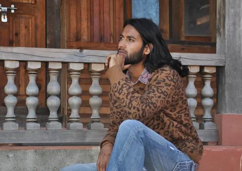 Side view of a attractive long haired Indian young man looking sideways Stock Photos