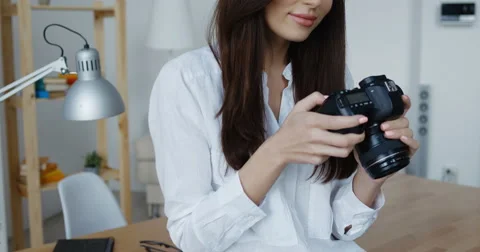Side view of attractive smiling brunette female photographer in white shirt Stock Footage 63442050
