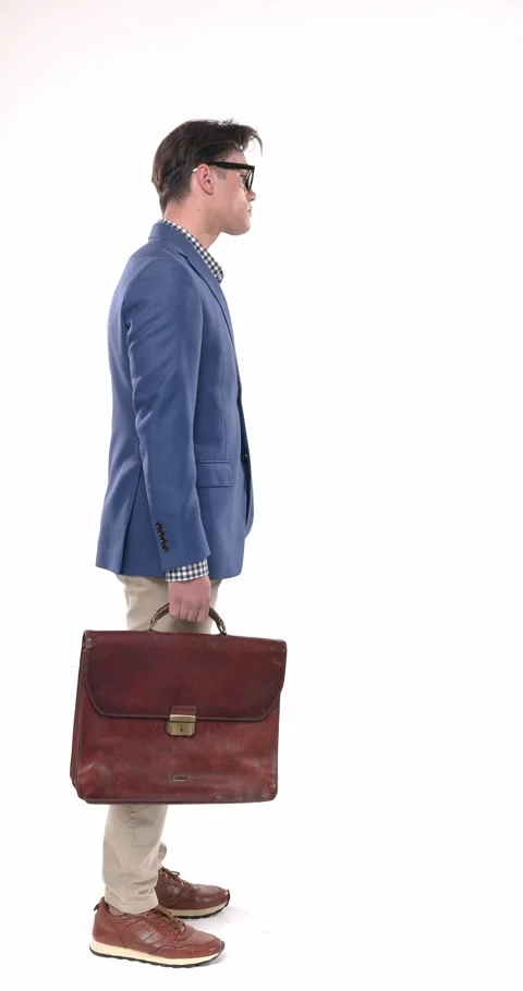 Side view attractive young man with glasses in blue jacket holding suitcase, Stock Footage 310043647