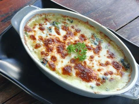 Side view of Baked spinach with cheese on a wooden table. Italian food Foto stock