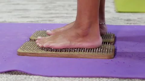 Side view barefoot dark skin woman legs stand on wooden sadhu yoga nails board. Stock Footage 266477420