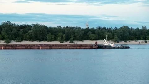 Side view of a barge in a river floating along the shore against beach and trees Vídeo Stock 133355383