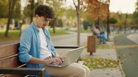 Side View of the Bearded Man Sitting on the Bench in the Street, Using his Stock Footage 237463218