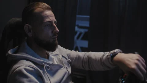 Side view of A bearded man using a driving simulator Video stock 258387289