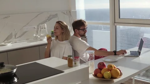 Side view of bearded man working on laptop computer sitting at home on a kitchen Stock Footage 123467866