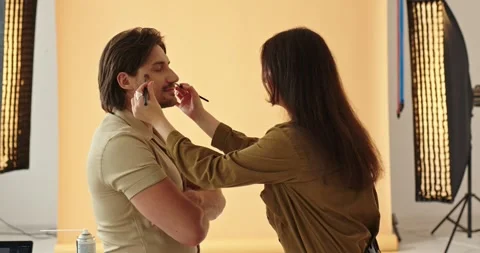 Side View Beautiful Female Makeup Artist Applying Makeup With Brush To Handsome  Stock Footage 279916261