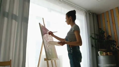 Side view of the beautiful talented young girl artist paints an oil painting Stock Footage 111032587