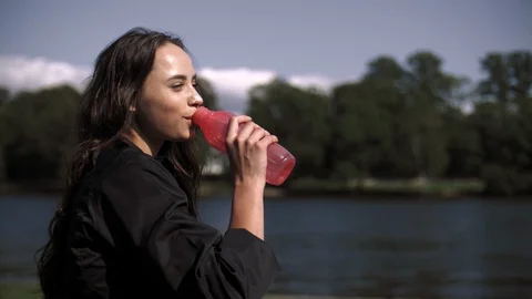 Side view of a beautiful young athletic girl drinks water from a bottle Stock Footage 114056290