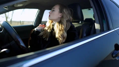 Side view of beautiful young lady looking in rear-view mirror adjusting hair Stock Footage 148755050