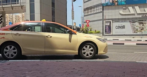 Side view of a beige taxi driving on a city street. Stock Footage 311892144