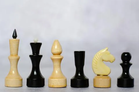 Side view of black and white chess pieces on a chessboard Stock Photos