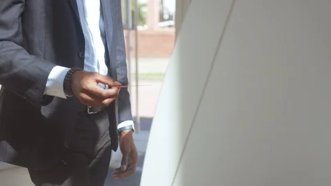 Side view of black businessman inserting a credit card into ATM cash machine Stock Footage 110446013