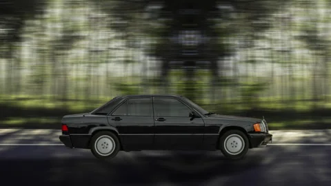 Side view of a Black Car driving on highway at high speed, forest background. Stock-Footage 332438730