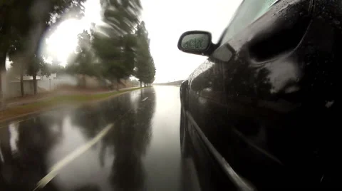 Side view of black car as it drives through rainy weather in hyperlapse Vídeos de archivo 45115737