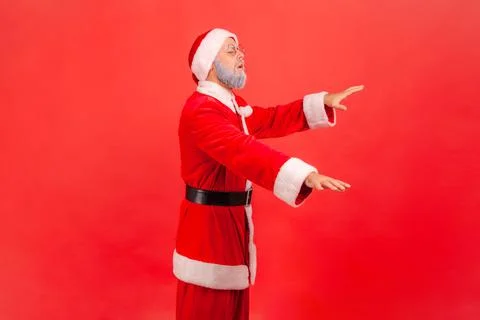 Side view of blind disoriented elderly man with gray beard wearing santa claus Foto stock