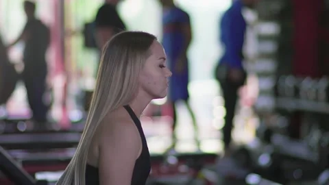 Side view of blonde woman does Lunges with dumbbells at gym Stock Footage 143516964