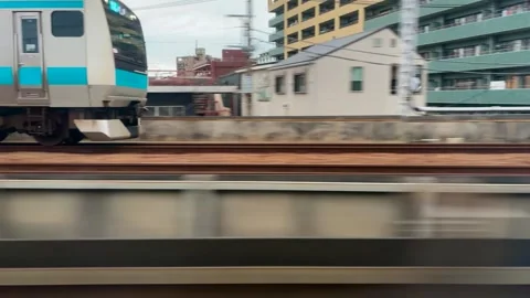 Side view of a blue and silver commuter train moving rapidly along the tracks. Stock Footage 334578627