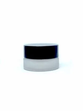 Side view of a blush container with a black lid screwed closed Stock Photos