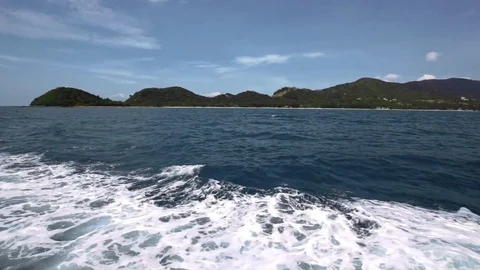 Side view from boat on foamy waves and island Stock Footage 71031837
