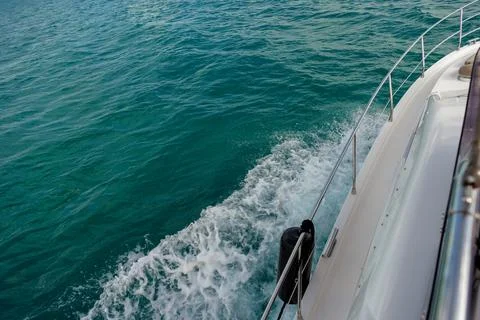Side view of a boat moving through turquoise water Stock Photos