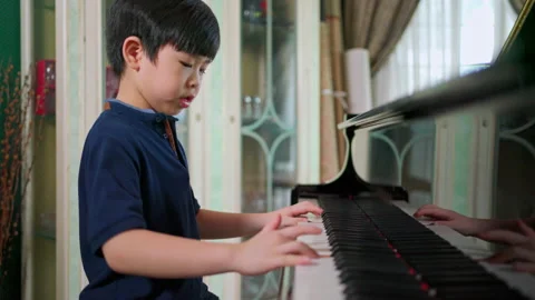 Side view of a boy learning piano Stock Footage 161066982